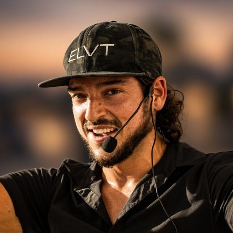 AJ Londono smiling, wearing an ELVT cap and a headset mic